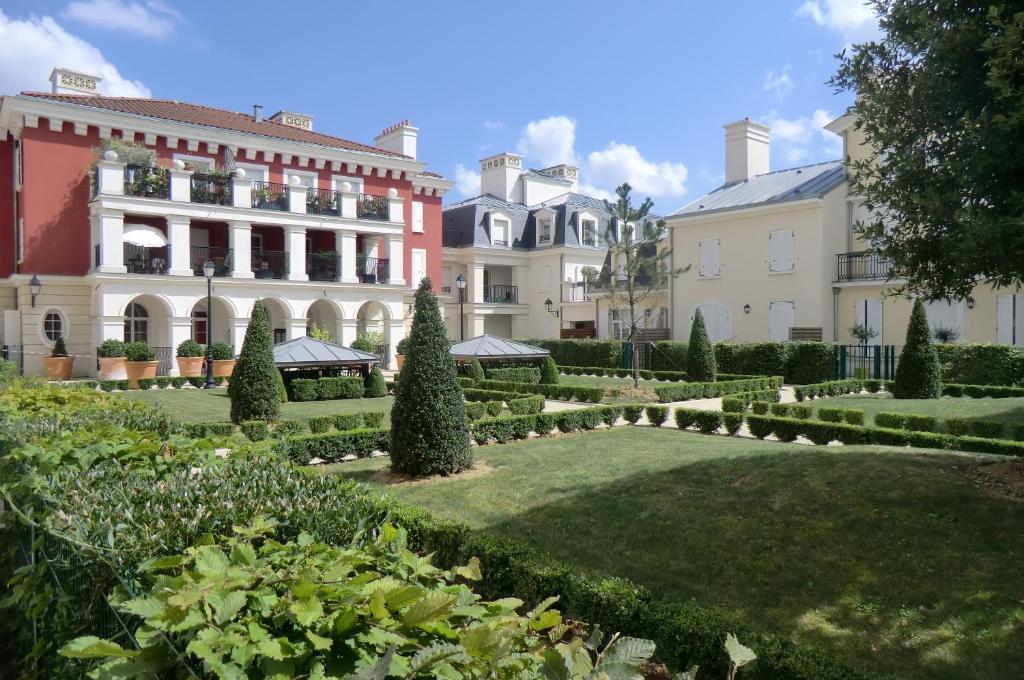 un jardin en face d'un grand bâtiment dans l'établissement Appartement Serris, à Serris