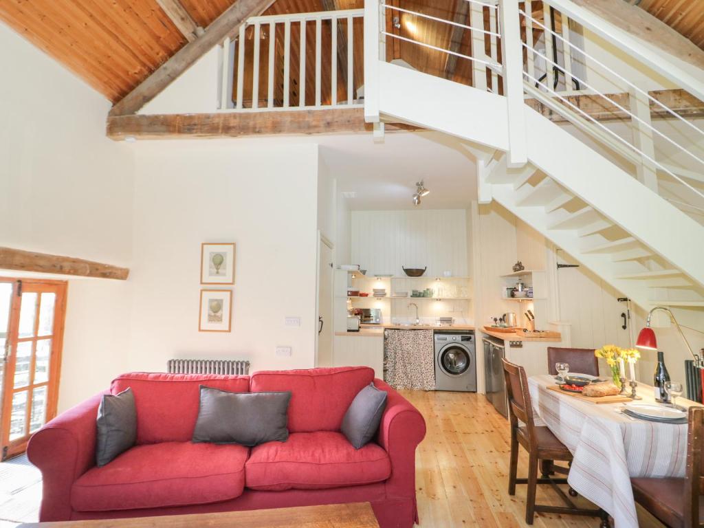 a living room with a red couch and a table at Ucheldref in Corwen