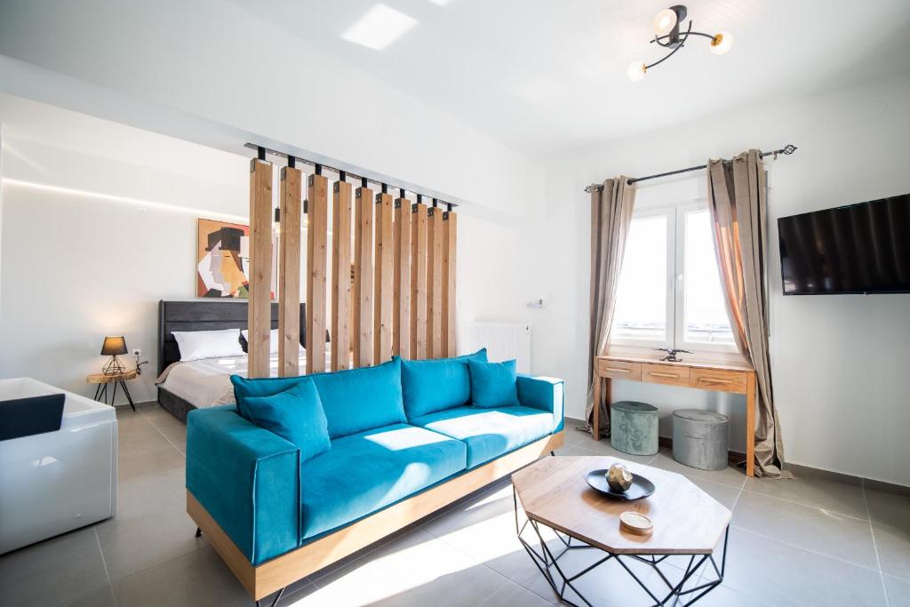 a living room with a blue couch and a bed at La Casa New Central Coastal Apartment & Jacuzzi in Volos
