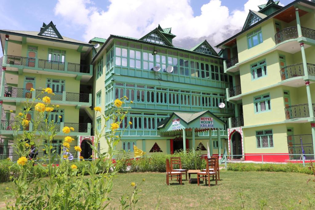 un edificio con sillas y una mesa frente a él en Hotel Mount Kailash, en Sāngla