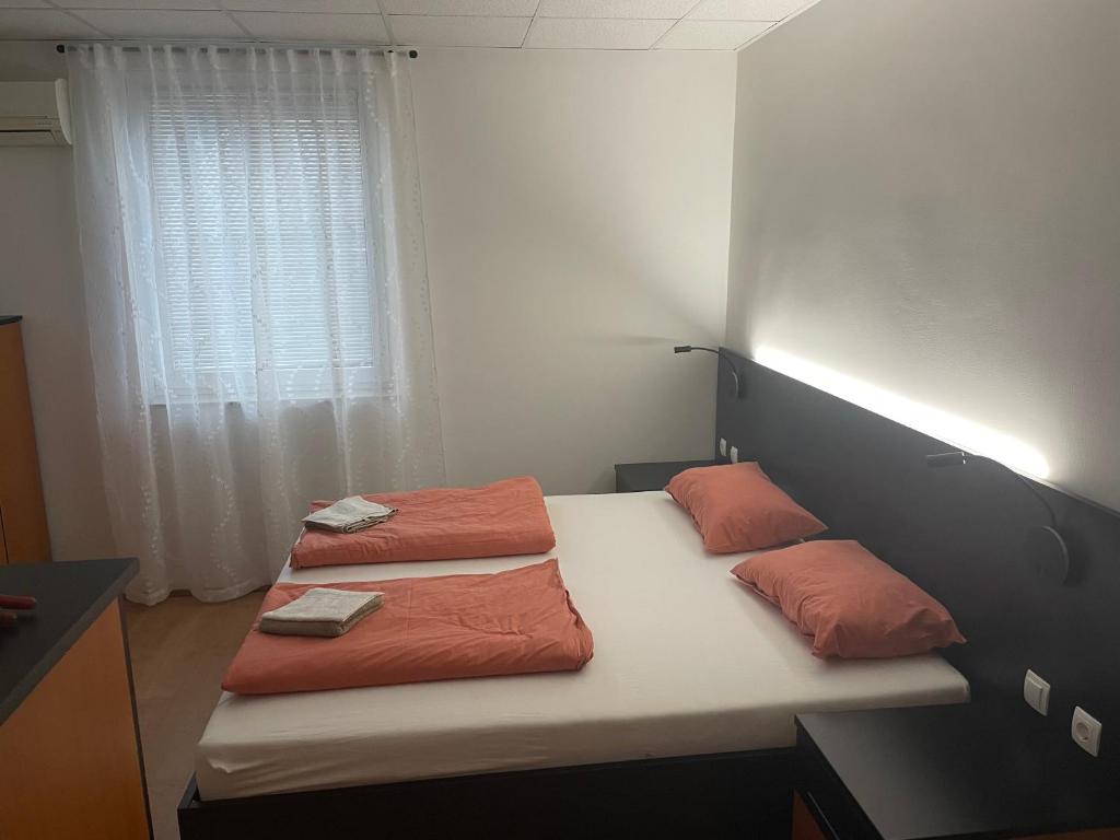 1 dormitorio con 2 camas con almohadas de color naranja en Room AA, en Dravograd