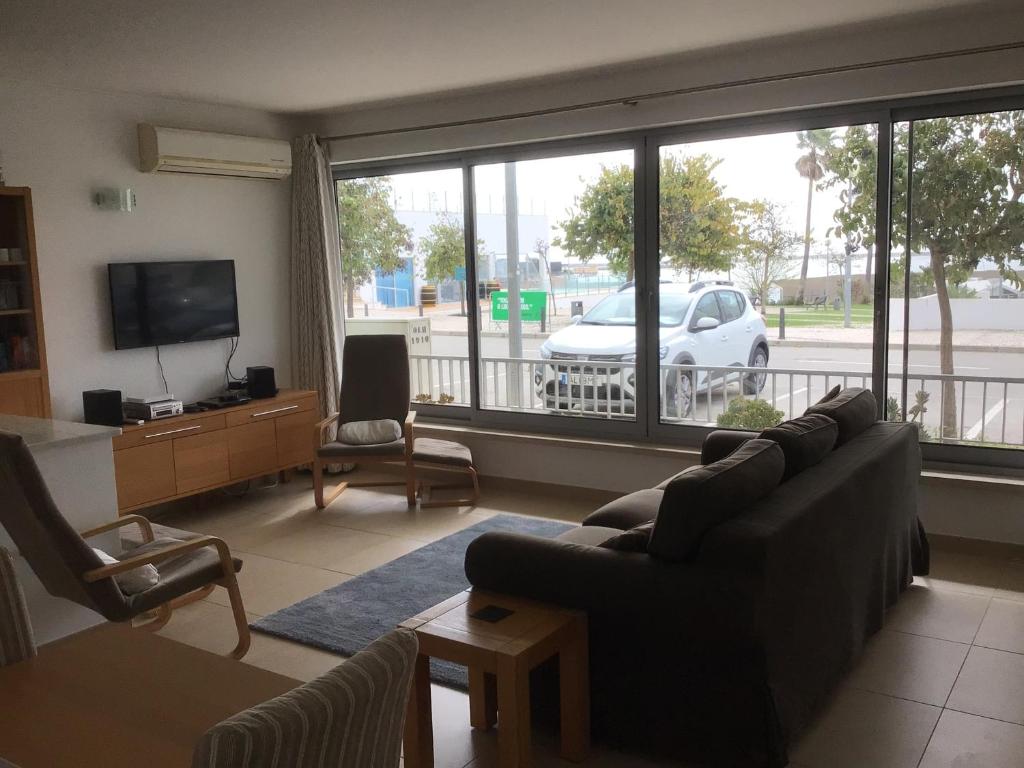 a living room with a couch and a large window at Rainha Juliana in Fuzeta