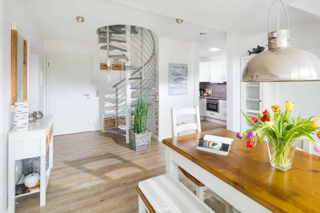 a kitchen with white walls and a wooden counter with flowers at Strandperle Ney in Norderney