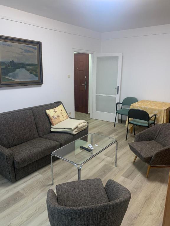 a living room with a couch and chairs and a table at Szabó Apartman in Miskolc