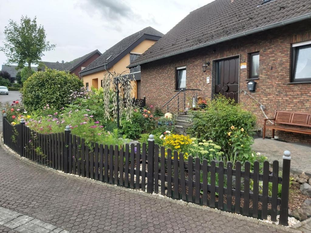 a garden in front of a house with a fence at Fewo Am Kendel in Kruft