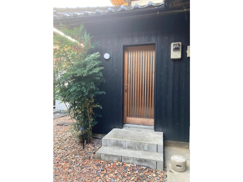 京丹後市にあるbase sanablend - Vacation STAY 39607vの木製のドアと階段のある黒い家