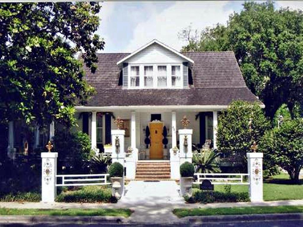 una casa blanca con puerta amarilla en Ducote-Williams House, en Abbeville