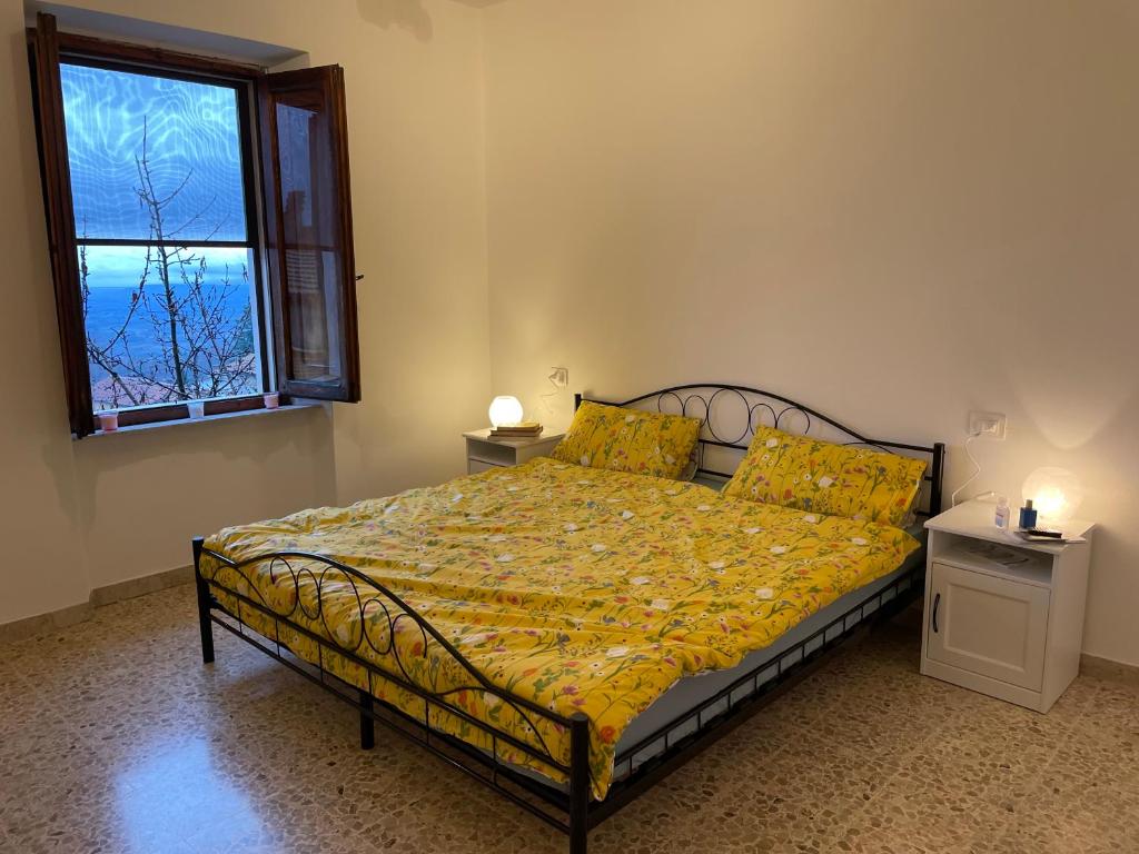 um quarto com uma cama com lençóis amarelos e uma janela em New Remodel & Garden - Entire House - EXCLUSIVE USE em Sassofortino
