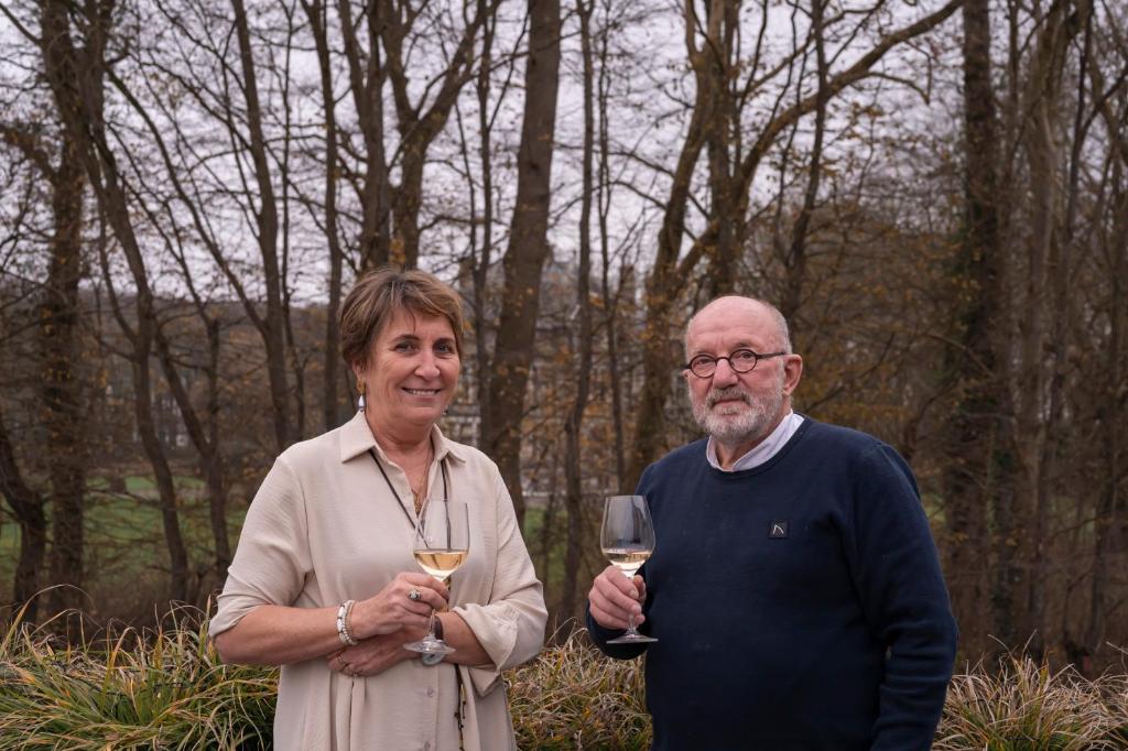 een man en een vrouw met een glas wijn bij B&B De Klaproos in Merkem