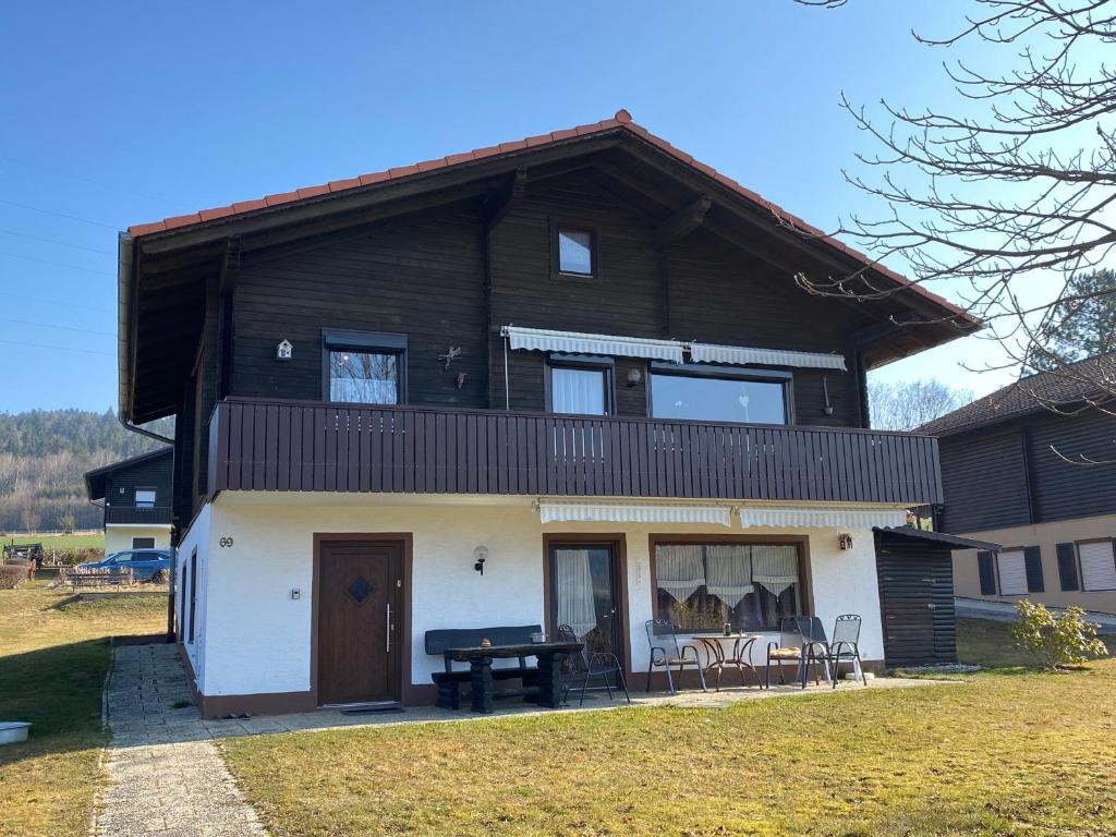 a house with a gambrel roof with a ping pong table at Feriendorf am Hohen Bogen Arrach Haus 69 in Arrach