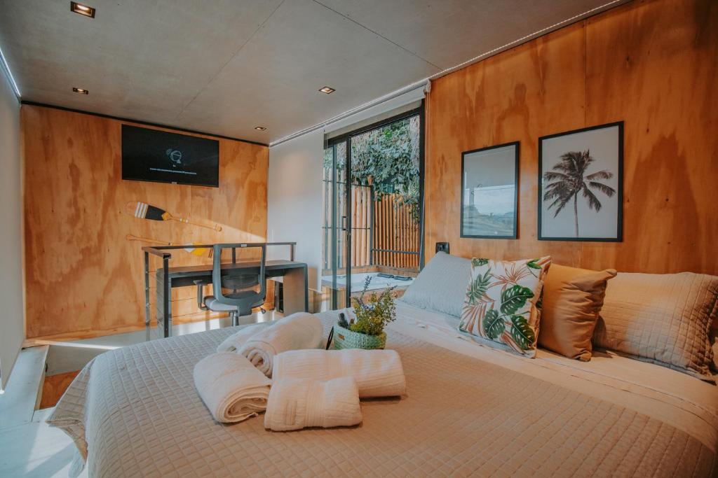 a bedroom with a large bed with two towels on it at Casa Natu Ilhabela Portinho in Ilhabela