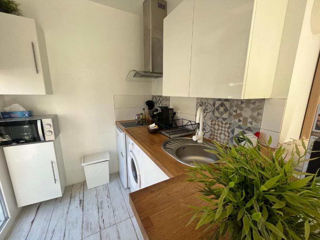 - une cuisine avec des placards blancs et un évier dans l'établissement Studio proche de la plage de l'almanarre, à Hyères