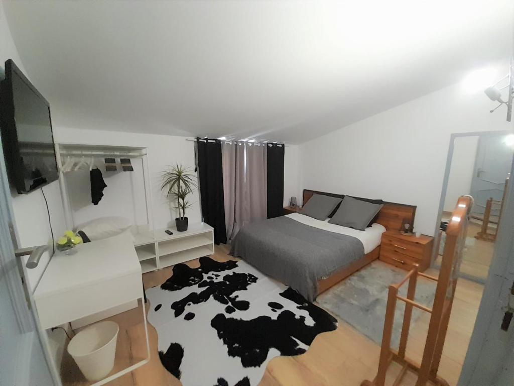 a bedroom with a bed and a black and white cow rug at Vasco da Gama Apartamento T2 com terraço PRAIA DA BARRA in Gafanha da Nazaré