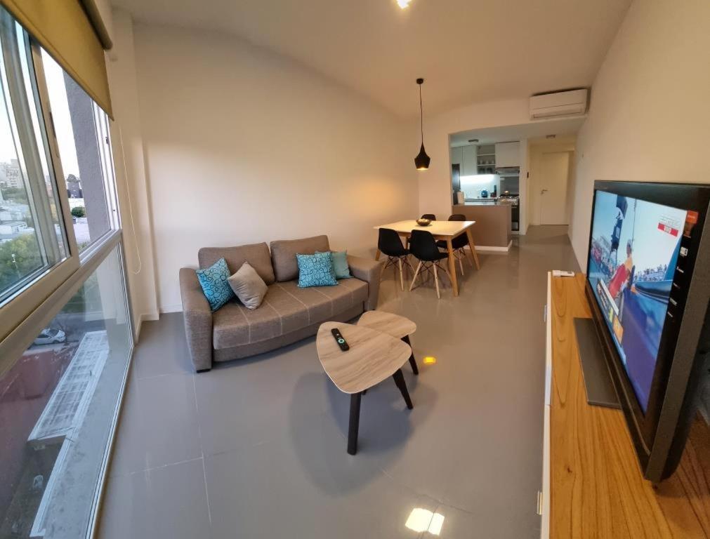 a living room with a couch and a tv and a table at Departamento Caleufu in Neuquén