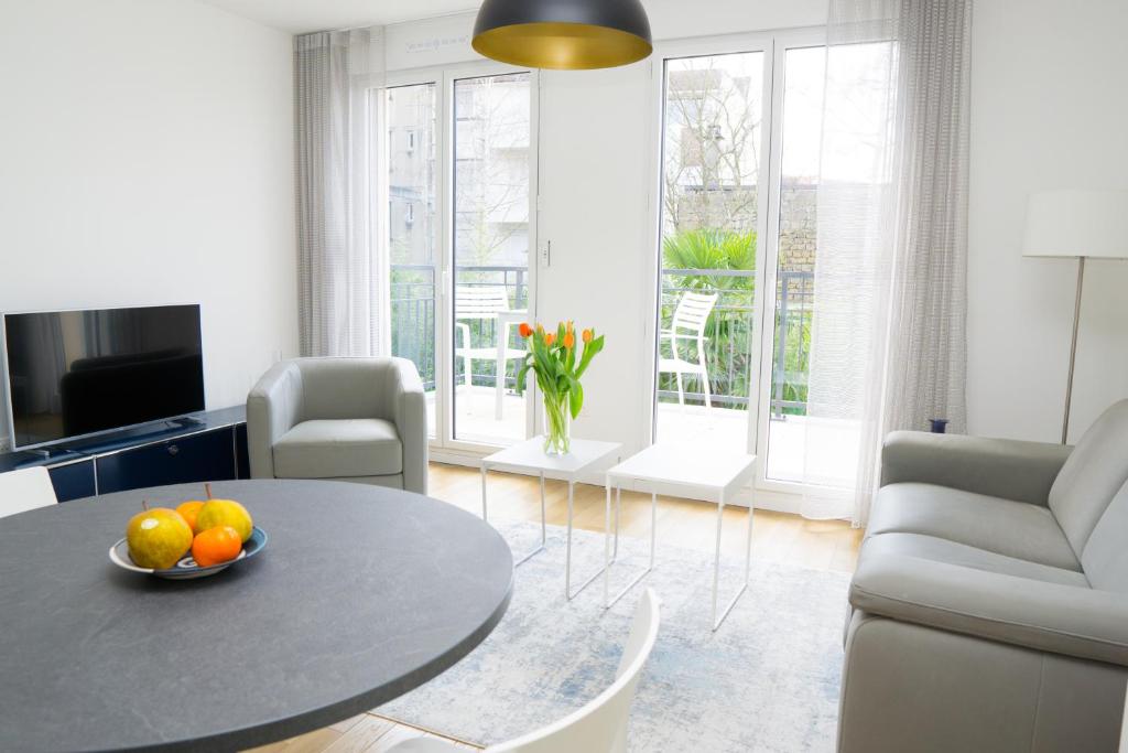 a living room with a table with fruit on it at EXIGEHOME-Appartement de standing en plein centre ville in Maisons-Laffitte