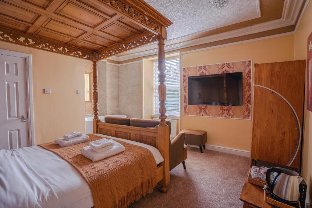 una camera con letto a baldacchino e TV di The Cottage a Windermere