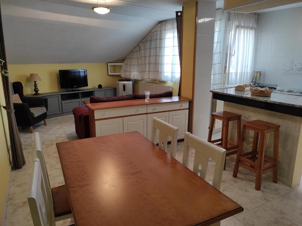 a kitchen and dining room with a wooden table at Alojaguay TORDESILLAS, LOFT con INFINITAS POSIBILIDADES in Tordesillas