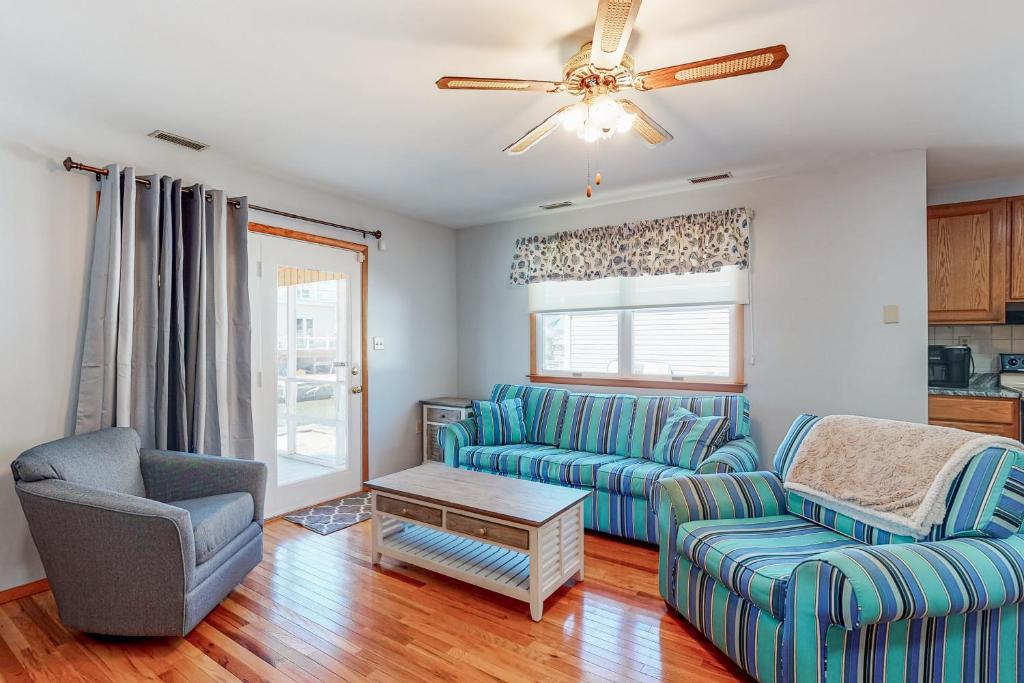 a living room with blue couches and a ceiling fan at Exeter Road Daydream in Ocean City