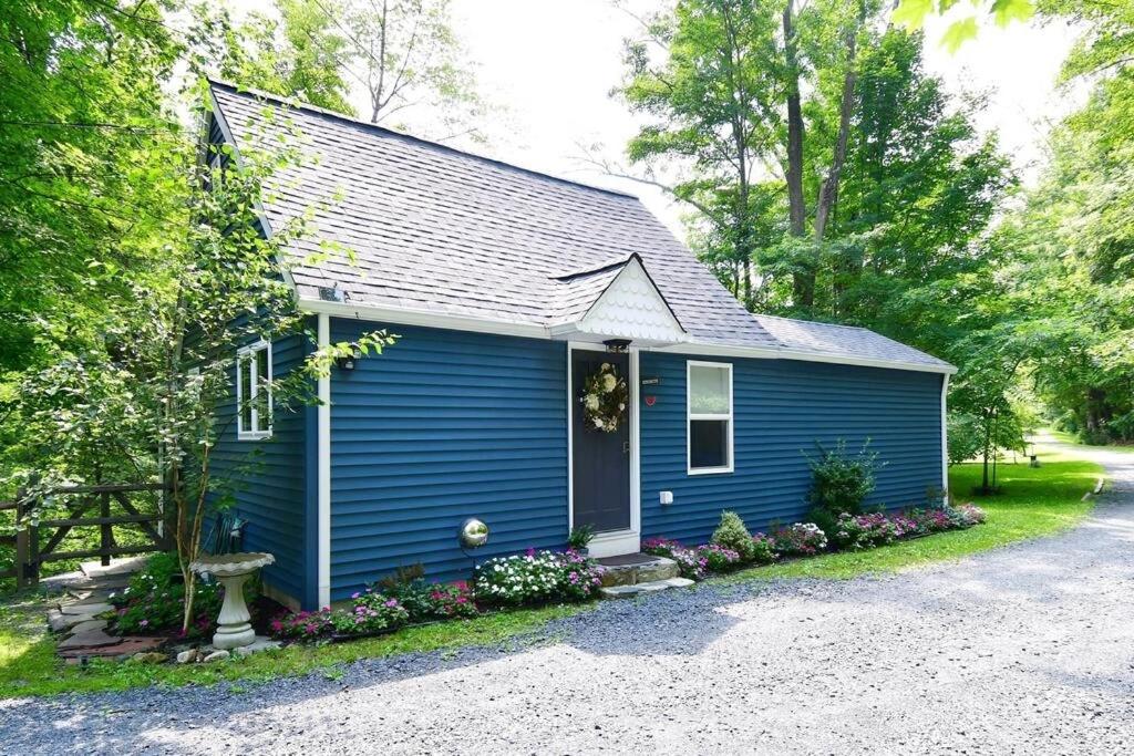 a blue house with flowers in front of it at Cottage at Millpond Falls - A Romantic Escape in Warwick