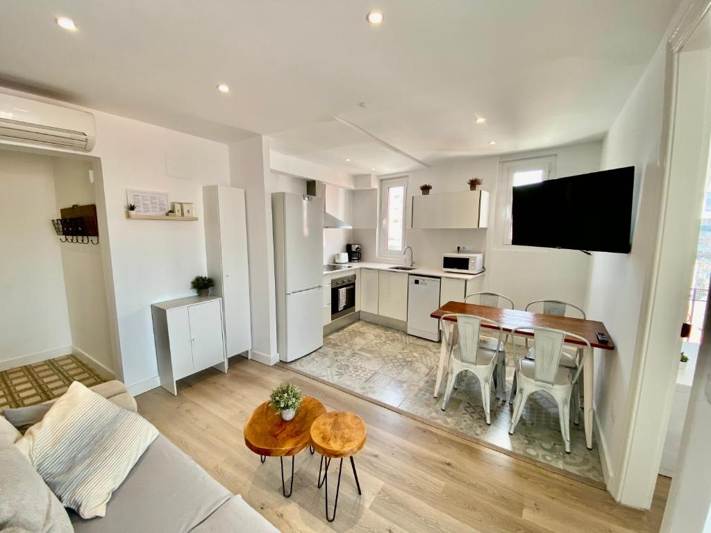 a living room with a table and a kitchen at Suite Apartment Anselm Barcelona in Cornellà de Llobregat