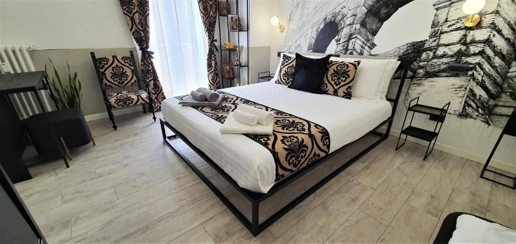 una camera da letto con letto, lenzuola e cuscini bianchi di Welcome Verona Rooms a Verona