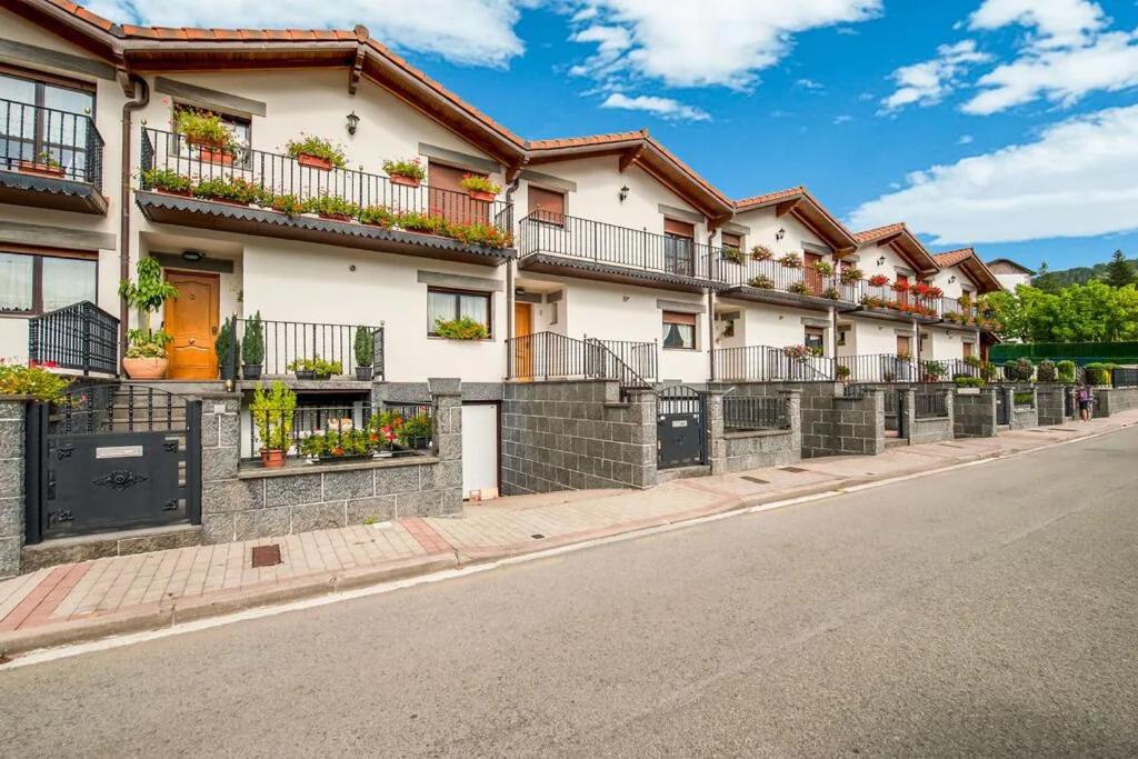 a row of apartment buildings on a street at Magnífica casa con jardin, BBQ e hidromasaje in Leitza