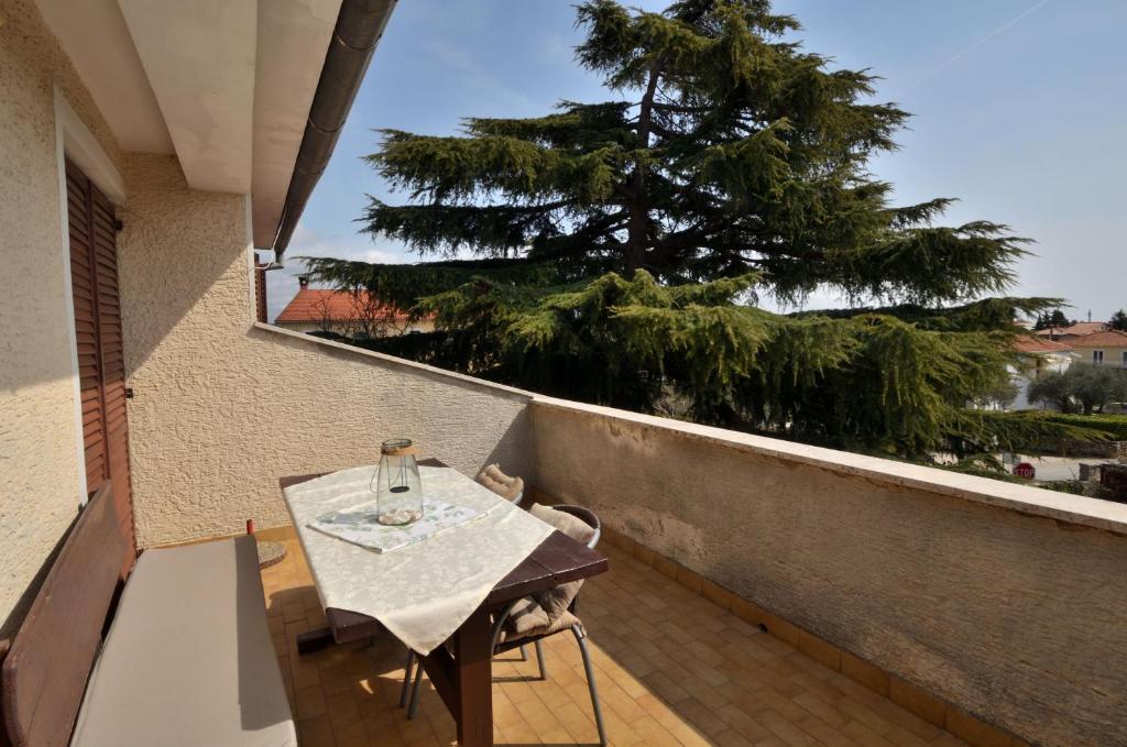 een tafel en stoelen op een balkon met een boom bij Apartments Medelin in Rovinj