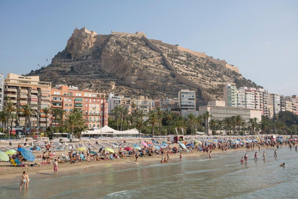 un grupo de personas en una playa con una montaña en 53-Piso en Alicante para 10 personas, en Alicante