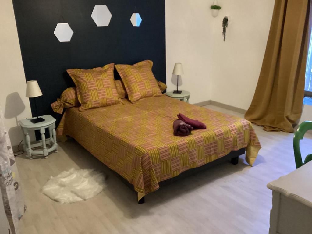 ein Schlafzimmer mit einem Bett mit einer braunen Decke in der Unterkunft Maison spacieuse et familiale in Pexonne