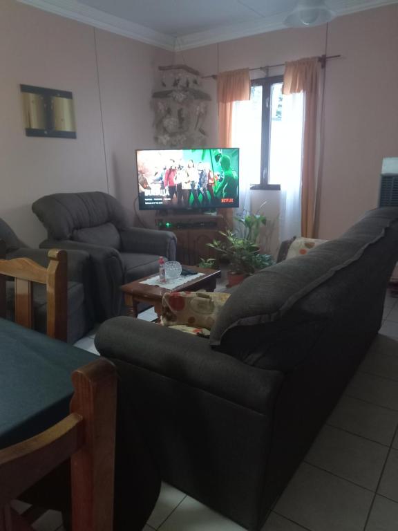 sala de estar con sofá y TV en Lo de Elena en Ushuaia