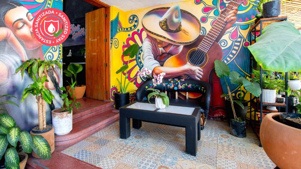 a room with a mural of a man playing a guitar at Hostal La Paz & Love Guadalajara in Guadalajara