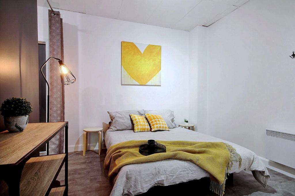 - une chambre avec un lit et une peinture jaune sur le mur dans l'établissement 18-26-30 Saint-Joseph Est, à Québec
