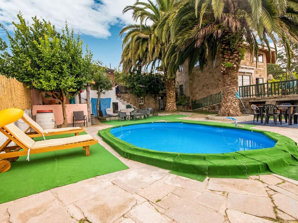 a swimming pool in a yard with a bench and trees at Spacious holiday home in Santiago de Compostela with pool in Eirapedriña