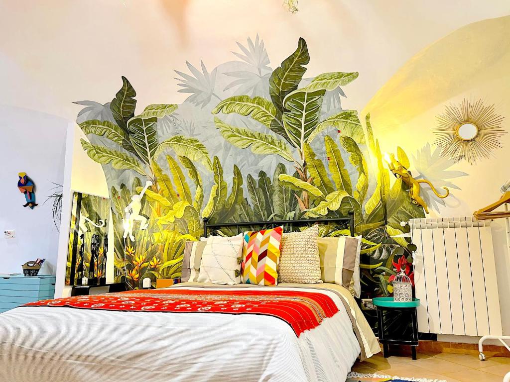 um quarto com uma cama com um mural de plantas em Apartment Napoli em Nápoles