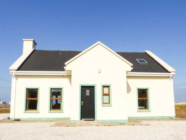 una casa bianca con tetto nero di 6 Strand Cottages a Doogort