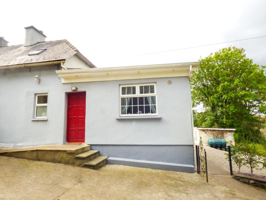 une maison blanche avec une porte rouge dans l'établissement Berrylane, à Enniscorthy