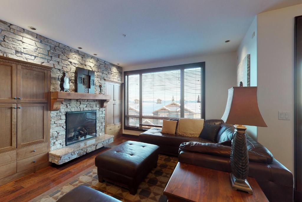 a living room with a couch and a fireplace at Aspens 3308 in Big White