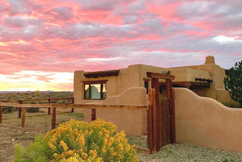 an old house in the desert with a sunset at Casa Allis Taos in El Prado