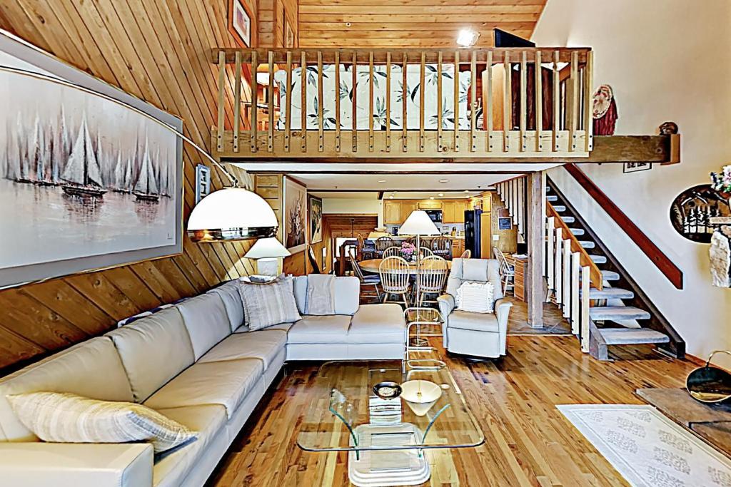 a living room with a couch and a staircase at Ridgepoint Haven 103 in Park City