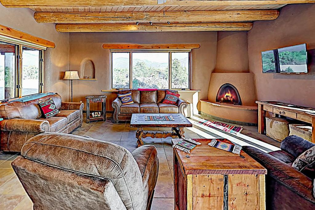 a living room with leather furniture and a fireplace at Casa Cielo in Taos