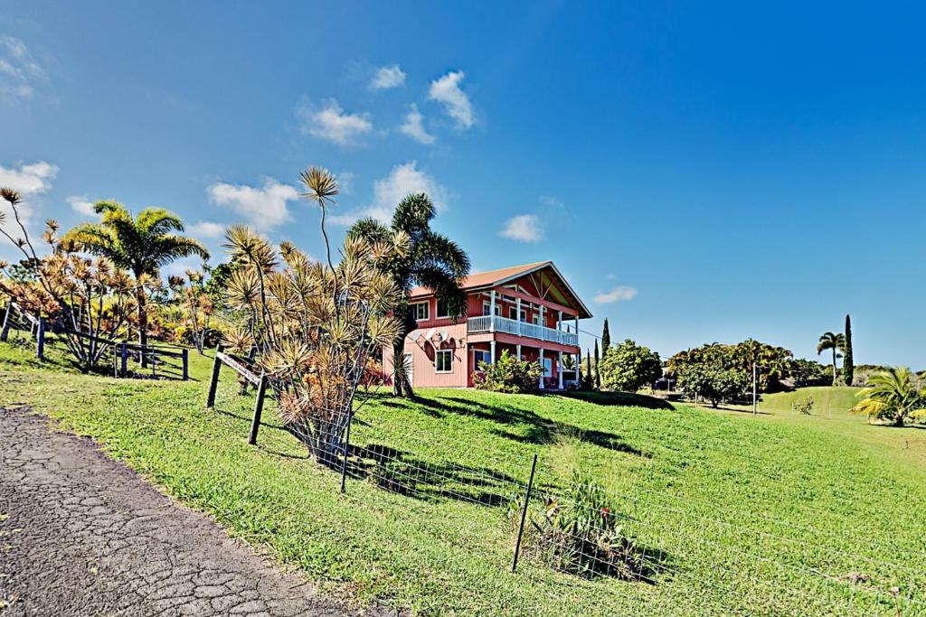 uma casa numa colina relvada com uma casa em Big Island Getaway, Ocean View Paradise em Ninole