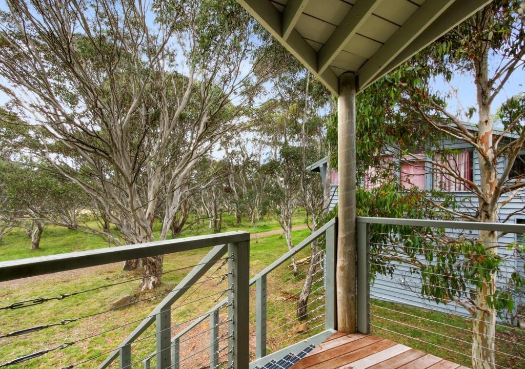 a porch with a view of a field and trees at Snowgums 18 in Dinner Plain