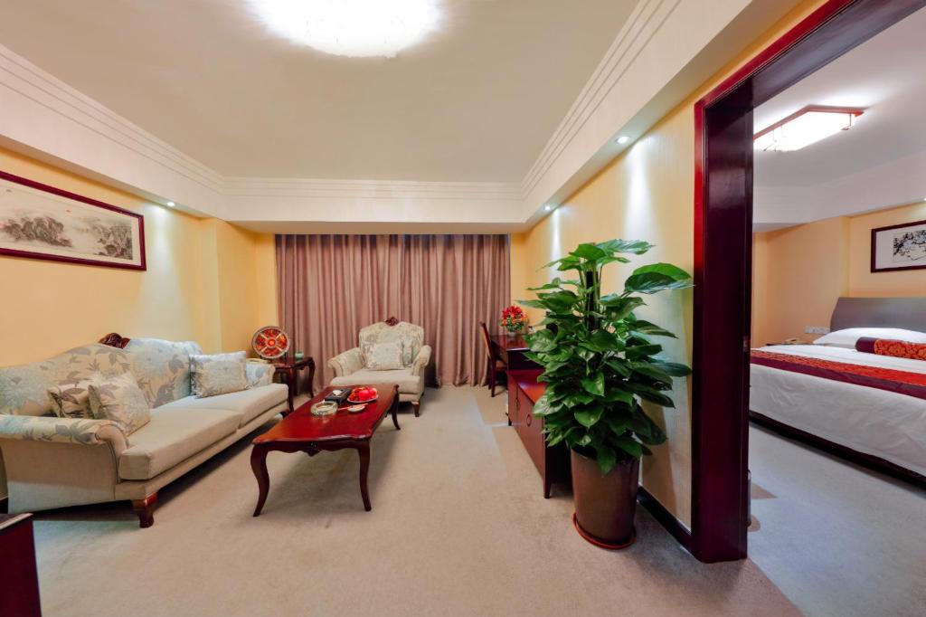 Habitación de hotel con cama y sala de estar. en Sanyu Hotel en Guangzhou