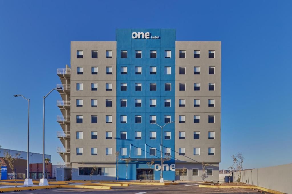 a tall building with a sign on top of it at One Chihuahua Norte in Chihuahua