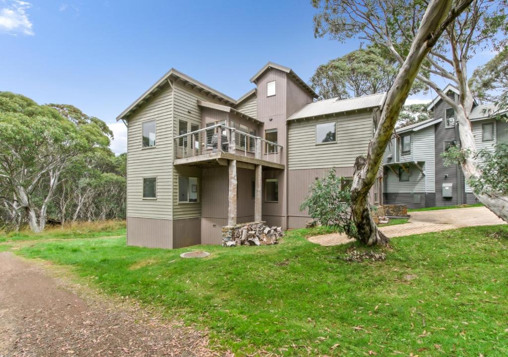 a large house with a balcony and a yard at Sun Dew in Dinner Plain