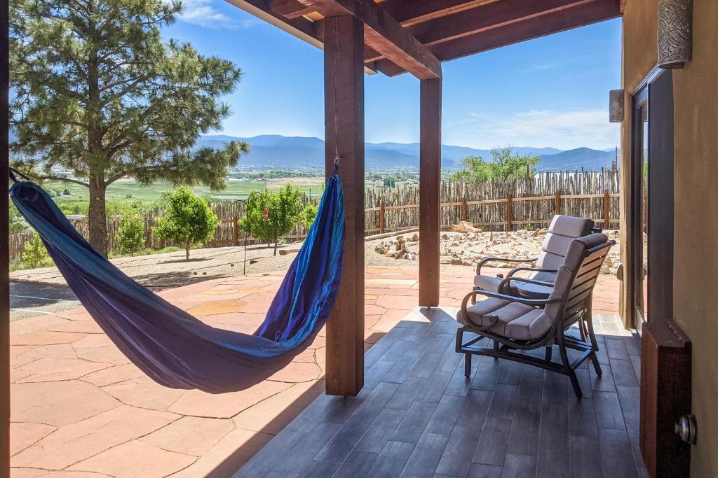 a porch with a hammock and a chair on a patio at Cottam Pines B in Taos