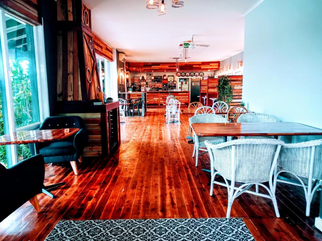 Redhill Cooma Motor Inn في كوما: غرفة طعام مع أرضيات خشبية وطاولات وكراسي