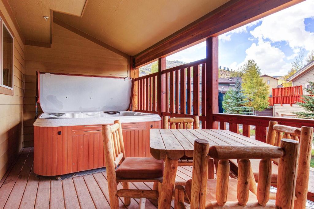 a porch with a table and a kitchen on a deck at Bobsled Haven in Park City