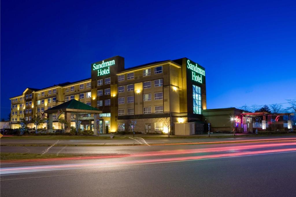 un edificio de hotel con luces de neón por la noche en Sandman Hotel Vancouver Airport, en Richmond