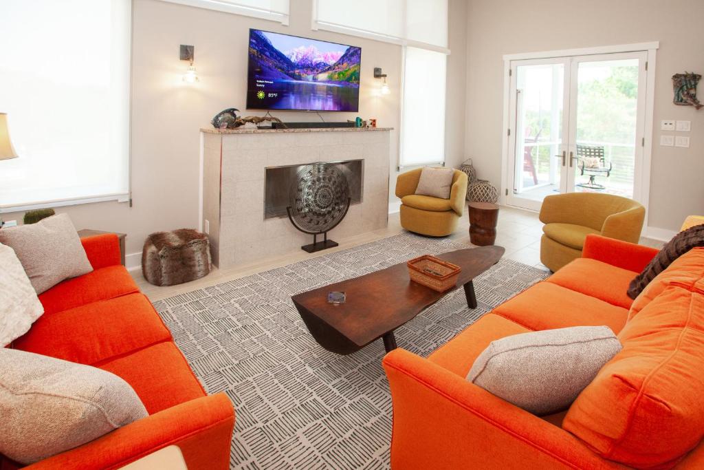 sala de estar con muebles de color naranja y chimenea en Sweet Sojourn, en Virginia Beach
